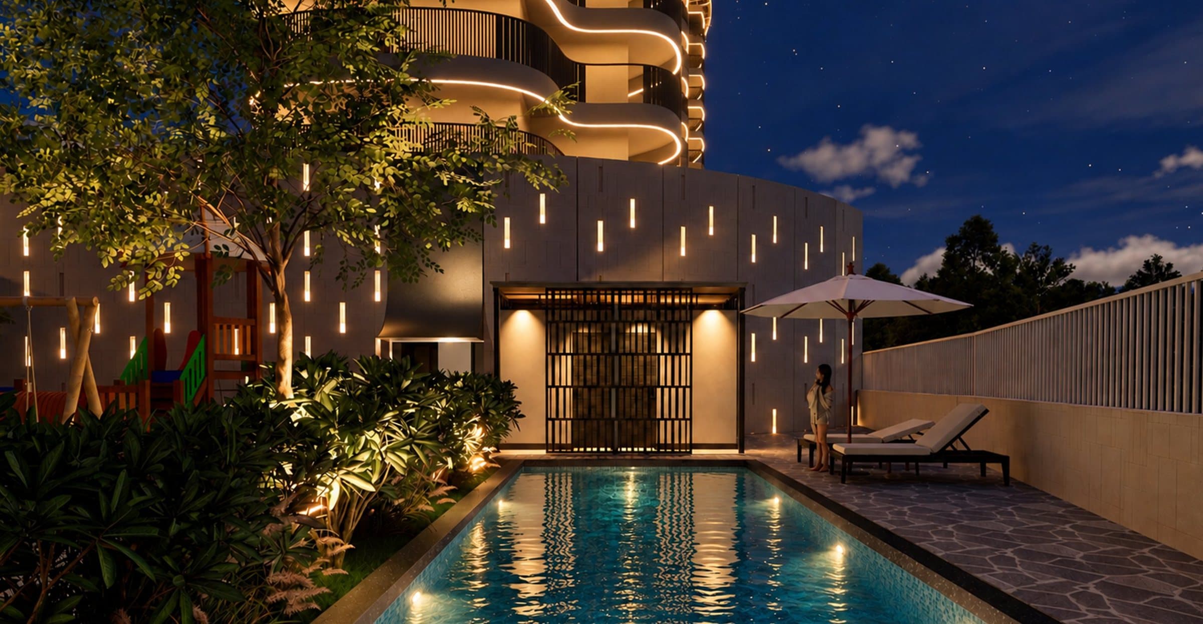 The pool after dark, lit by warm light from the clubhouse